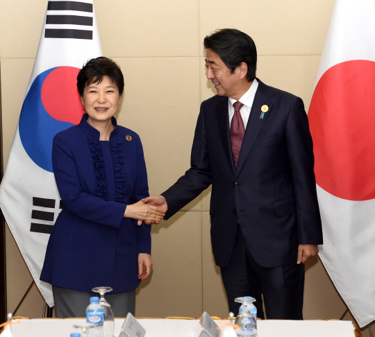 박근혜 대통령과 아베 신조 일본 총리가 7일 라오스 비엔티안 국립컨벤션센터(NCC)에서 만나 정상회담을 하기에 앞서 악수하고 있다. /비엔티안=연합뉴스