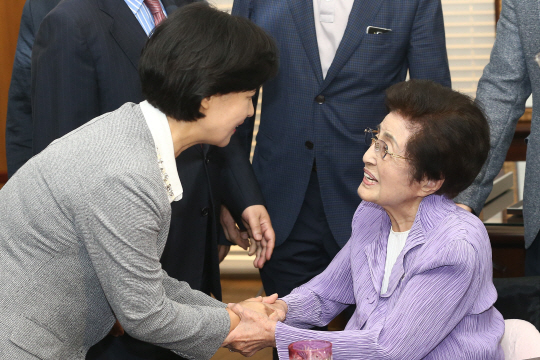 더불어민주당 추미애 대표가 7일 서울 마포구 김대중도서관에서 이희호 여사를 예방하며 손을 잡고 있다./연합뉴스