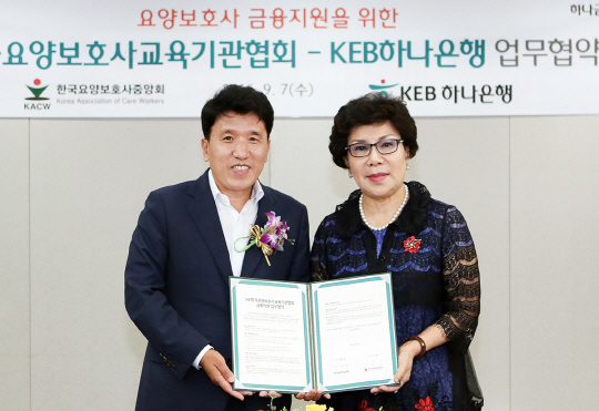 함영주(왼쪽) KEB하나은행장과 민소현 한국요양보호사교육기관협회장이 지난 7일 서울 을지로 KEB하나은행 본점에서 요양보호사의 권익 및 복지 증진을 위한 금융지원 업무협약을 체결한 뒤 협약서를 들어보이고 있다./사진제공=KEB하나은행