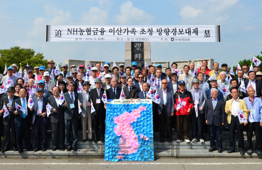 김용환 NH농협금융지주 회장(앞줄 오른쪽 8번째)이 이산가족과 함께 직접 만든 한반도 모양의 무궁화 꽃 조형물을 배경으로 기념촬영을 하고 있다. /사진제공=NH농협금융지주