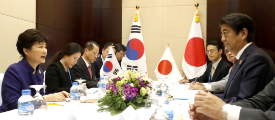 박근혜 대통령과 아베 일본 총리가 지난 7일 오후(현지시간) 라오스 비엔티안 국립컨벤션센터(NCC)에서 열린 한·일 정상회담에서 양국 현안에 대해 논의하고 있다./연합뉴스