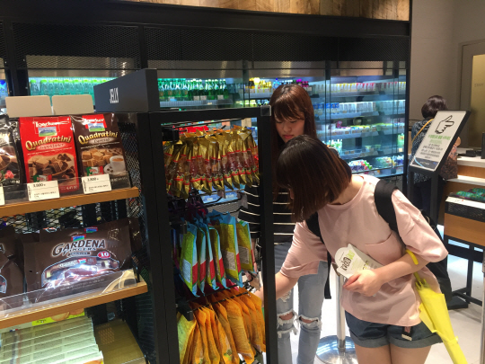 9일 서울 명동 올리브영에서 일본인 관광객들이 한국 간식 제품을 둘러보고 있다./이지윤기자