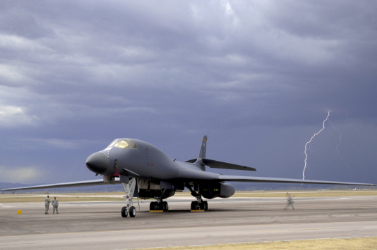 번개가 치는 가운데 활주로에서 대기 중인 B-1B 전략폭격기. 전천후 성능을 자랑하지만 고성능의 전자기기가 많아 강풍을 동반한 낙뢰 상황에서는 이륙을 제한하는 경우가 많다. 13일 괌 공군기지 주변의 기상 예보도 고르지 못해 한반도 전개가 또다시 연기될 가능성이 있다.