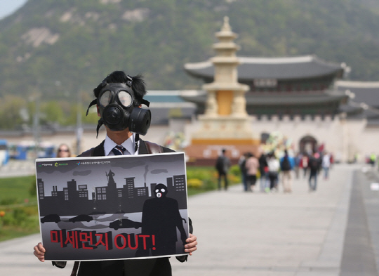 서울 종로구 광화문 광장에서 서울환경운동연합의 한 활동가가 방독면을 쓴 채 정부의 미세먼지 대책을 촉구하는 시위를 벌이고 있다.