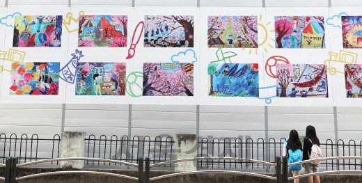 서울 강동구에 위치한 래미안 솔베뉴 건설 현장 가림벽에 인근 초등학교 학생들이 그린 그림이 전시돼 있다. 삼성물산은 안전시설로만 활용했던 가림벽을 지역 주민들을 위한 공간으로 탈바꿈 시켰다. /사진제공=삼성물산