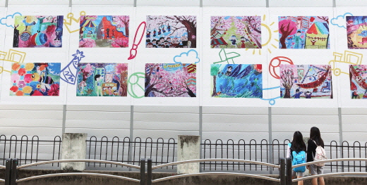 서울 강동구에 위치한 래미안 솔베뉴 건설 현장 가림벽에 인근 초등학교 학생들이 그린 그림이 전시돼 있다. 삼성물산은 안전시설로만 활용했던 가림벽을 지역 주민들을 위한 공간으로 탈바꿈시켰다. /사진제공=삼성물산