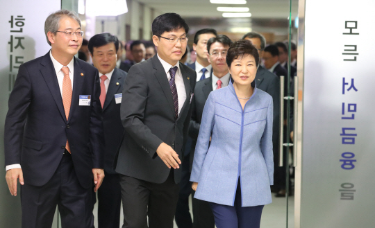 박근혜 대통령이 23일 한국프레스센터에서 열린 서민금융진흥원 개소식에서 임종룡(왼쪽) 금융위원장과 함께 현판 제막을 마친 뒤 센터 안으로 들어서고 있다.  /연합뉴스