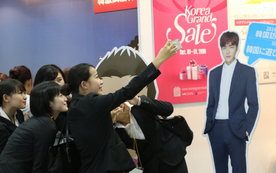 23일 도쿄 빅사이트에서 열린 투어리즘 엑스포 재팬 한국관의 관람객들이 ‘한국방문의 해’ 홍보대사 이민호의 사진을 배경으로 셀카를 찍고 있다.