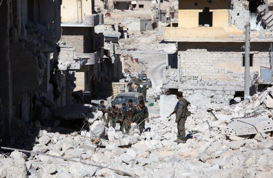 24일(현지시간) 시리아 정부군 병사들이 공습으로 폐허가된 알레포를 순찰하고 있다./알레포=AFP연합뉴스