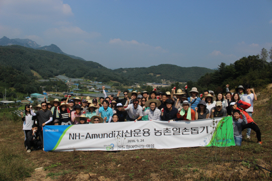 NH-아문디자산운용 임직원들이 지난 24일 자매결연마을인 경기 가평군 율길1리에서 자원봉사활동을 마친 후 기념사진을 찍고 있다. /사진제공=NH-아문디운용