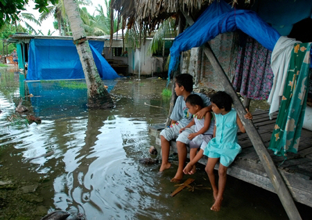 남태평양 투발루 푸나푸티 섬의 아이들이 차오른 바닷물에 잠긴 마을에서 홍수가 빠져나가기를 기다리고 있다.