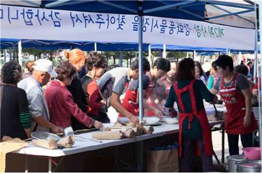 [사진: 지난해 제1회 강화풍물시장 대축제에서 음식을 나눠주는 강화풍물시장 상인]