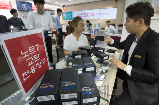 배터리 폭발 문제가 발생한 삼성전자의 스마트폰 ‘갤럭시노트7’에 대한 교환이 시작된 지난달 19일 서울 마포구 한 SKT매장에 갤럭시노트7 구매자가 교환을 하고 있다.                                         /권욱기자