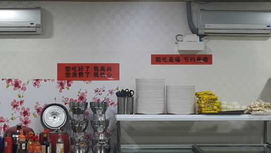 음식이 비치된 뷔페 코너 위에 중국어로 쓰여진 안내문이 붙어있다. 무슨 뜻일까? /변재현 기자