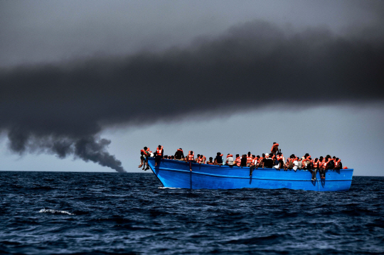 3일(현지시간) 리비아 연안 지중해에서 난민들이 탄 배가 표류하며 구조를 기다리고 있다. 이탈리아 해안경비대는 이날 하루에만도 난민 6,055명을 구조해 하루 기준 역대 최대 구조기록을 세웠다고 밝혔다.    /지중해=AFP연합뉴스