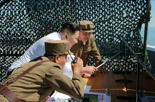 김정은 북한 노동당 위원장이 지난 9월 20일 신형 정지위성 운반 로켓용 엔진 분출 시험 장면을 지켜보는 모습이다./연합뉴스