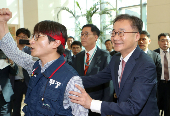 정찬우 신임 한국거래소 이사장이 4일 거래소 본사가 있는 부산국제금융센터 1층에서 이사장 출근을 저지하는 노조 측과 대화를 시도하려는 듯 팔을 붙들고 있다. 정 신임 이사장은 이날 취임식을 진행하려 했지만 노조 측의 취임 반대 실력 저지로 무산됐다.  /연합뉴스