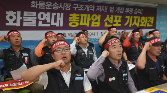 민주노총 공공운수노조 화물연대본부 조합원들이 지난 5일 오전 서울 중구 민주노총 대회의실에서 정부의 ‘화물운송시장 발전방안’ 저지를 위한 총파업 돌입 계획을 밝힌 뒤 구호를 외치고 있다./송은석기자