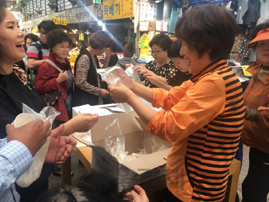 8일 오후 서울 수유시장에서 코리아페스타 기념으로 열린 가래떡 나누기 행사에 참여한 사람들이 줄을 서서 가래떡을 받고 있다./백주연 기자