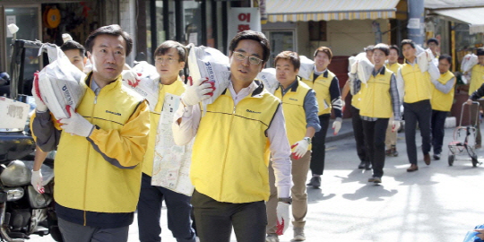 김한기(앞줄 왼쪽) 대림산업 사장이 10일 창립 77주년 기념일을 맞아 임직원들과 함께 서울 종로구에서 독거노인과 장애인들을 위해 ‘사랑의 쌀’을 배달하고 있다. /사진제공=대림산업