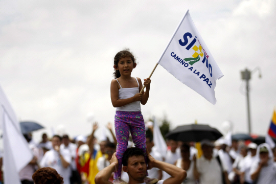 9일(현지시간) 콜롬비아 서남부 도시 칼리에서 열린 내전종식 집회에서 한 소녀가 ‘SI+NO X CAMINO A LA PAZ(찬성과 반대 모두 평화를 위해)’라는 문구가 적힌 깃발을 들고 서 있다. 이날 시민들은 정부와 반군인 콜롬비아무장혁명군(FARC) 사이의 내전이 끝나기를 바라며 지난 7일 부결된 국민투표 이후 진전되지 못한 양측의 평화협정이 제대로 실현돼야 한다고 요구했다.  /칼리=EPA연합뉴스