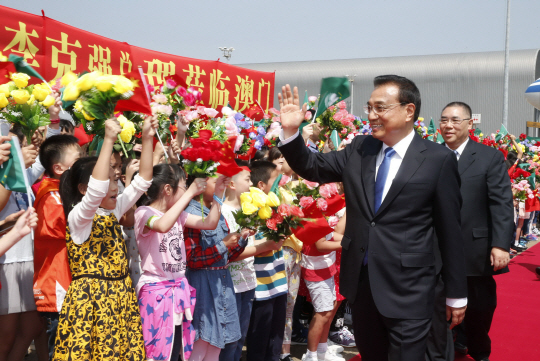지난 10일 리커창 중국 총리가 마카오 특별 행정지구를 방문해 자신을 환영하는 어린이들에게 손을 들어 인사하고 있다. /마카오=신화연합뉴스