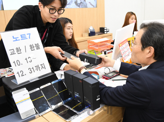 한 남성 고객(오른쪽)이 13일 서울 강남구 SKT 직영 매장을 방문해 ‘갤럭시노트7’을 ‘갤럭시S7엣지’로 교환받고 있다. 삼성전자는 갤노트7 단종을 결정하고 이날부터 이동통신사와 직영매장 등을 통해 교환·환불을 시작했다. 최초 구매한 매장에서 진행되며 살 때 받았던 기어핏2 등 사은품은 반납하지 않아도 된다. /송은석기자