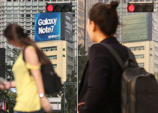 최근까지도 서울시내 한 건물에 걸려 있던 갤럭시노트7의 광고판(왼쪽 사진)이 해당 제품 단종 후인 14일에는 가림막(오른쪽 사진)으로 가려져 있다.  /연합뉴스