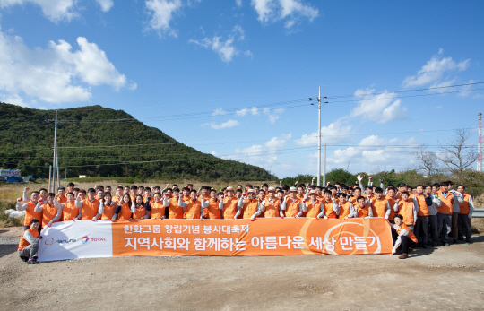 한화토탈 임직원 300여명이 지난 10일 대산사업장 인근 황금산방파제에서 환경정화 활동을 펼치고 파이팅을 외치고 있다. 한화그룹이 창립 64주년을 맞아 10월 한 달 동안 임직원 릴레이 봉사활동을 펼친다. /사진제공=한화그룹