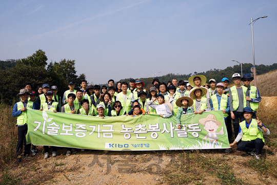 기술보증기금 임직원과 가족들이 지난 15일 경기도 화성시 장전마을에서 농촌 봉사활동을 하기에 앞서 기념 촬영을 하고 있다. /사진제공=기술보증기금