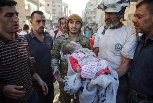 17일(현지시간) 격전이 벌어지고 있는 시리아 알레포에서 시리아민간방위대인 화이트 헬멧 소속 대원들이 무너진 건물 잔해 속에서 어린 여자아기를 꺼내 옮기고 있다. /시리아=AFP연합뉴스