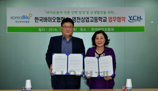 김호열(왼쪽) 한국바이오협회 부회장과 오선미 영천상업고등학교 교장이 18일 판교 코리아바이오파크에서 바이오산 업 전문 인력양성을 위한 양해각서(MOU)를 체결한 뒤 협약서를 들어보이고 있다. 영천상고는 2018년 학교 이름을 한국식품과학마이스터고(가칭)로 바꾸고 식품 및 바이오품질관리과 신입생 60여명을 모집한다. /사진제공=바이오협회