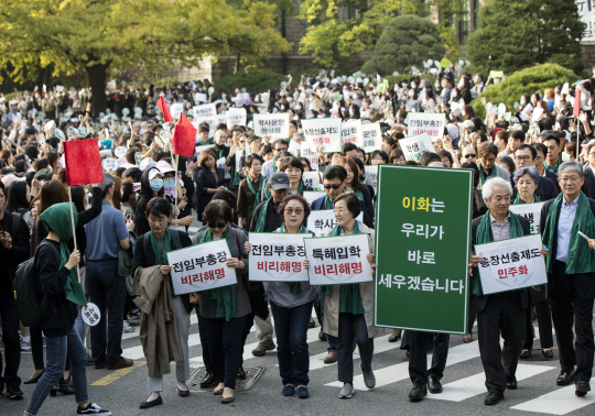 이화여대 교수들과 학생들이 19일 오후 서울 서대문구 이화여대 본관 앞에서 정권의 ‘비선 실세’로 지목된 최순실씨의 딸이 특혜 입학했다는 의혹에 휩싸인 이화여대 최경희 총장의 해명 등을 요구하며 행진을 하고 있다./연합뉴스