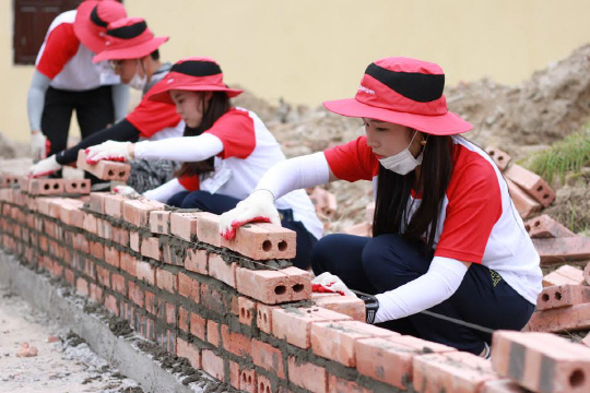 LG디스플레이 임직원들이 베트남 북부 하이퐁시 빈바오현 짠즈엉중학교에서 시설 환경 개선 봉사활동을 하고 있다./사진제공=LG디스플레이