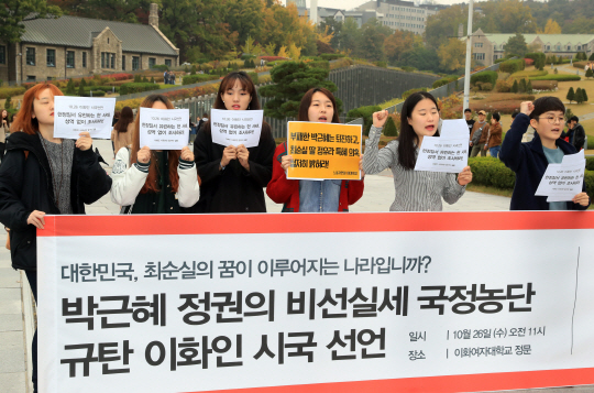 이화여대 학생들이 26일 오전 서울 서대문구 이화여대 정문 앞에서 열린 ‘박근혜 정권의 비선 실세 국정농단 규탄 이화인 시국선언’에 참가해 피켓을 들고 구호를 외치고 있다. 이들은 ‘대통령을 포함한 관련자들을 성역 없이 조사하라’고 요구했다. /연합뉴스