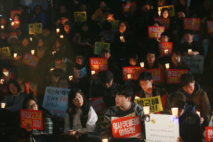 한국사교과서국정화저지네트워크 관계자들이 지난해 11월 서울 청계광장 인근에서 결의대회를 열고 촛불과 ‘한국사 교과서 국정화 저지!’ 등의 메시지가 적힌 손팻말을 들고 있다. /연합뉴스