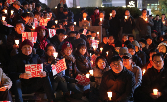 1일 오후 서울 광화문 파이낸스빌딩 인근에서 열린 ‘박근혜 대통령 하야 촉구 촛불집회’에서 시민들이 촛불을 들고 있다. /연합뉴스