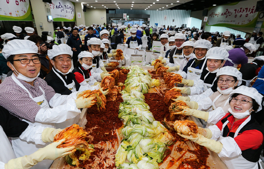 한국 지엠 한마음 재단 회원과 가족들이 지난해 11월 인천시 부평구 한국 지엠 본사에서 사회북지시설에 전달할 김장 김치를 담그고 있다. /사진제공=한국 지엠