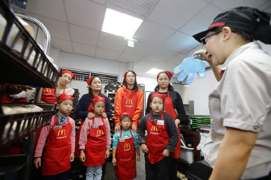 지난 4일과 5일 전국 맥도날드 매장에서 진행된 맥도날드 ‘내셔널 오픈데이’ 행사에 참여한 어린이와 엄마 고객이 매장 직원을 실명을 듣고 있다./사진제공=맥도날드