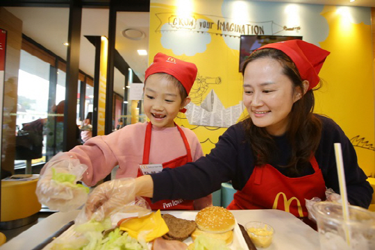 지난 4일과 5일 전국 맥도날드 매장에서 진행된 맥도날드 ‘내셔널 오픈데이’ 행사에 참여한 어린이와 엄마 고객이 ‘나만의 빅맥’을 만들고 있다./사진제공=맥도날드