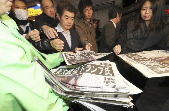 9일 저녁 일본 도쿄 시민들이 제45대 미국 대통령선거에서 도널드 트럼프 공화당 후보가 승리했다는 소식을 전하는 요미우리신문 호외를 앞다퉈 집어들고 있다. /도쿄=AP연합뉴스