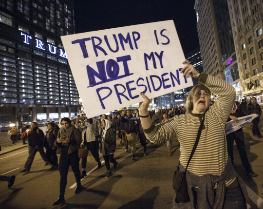 9일(현지시간) 미국 일리노이주 시카고에서 반트럼프 집회에 참여한 한 여성이 ‘트럼프는 나의 대통령이 아니다’라는 피켓을 들고 행진하고 있다./AFP연합뉴스