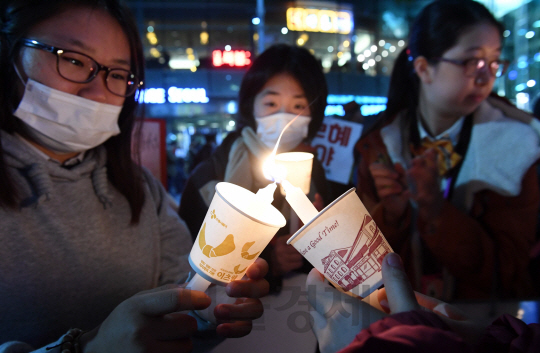 박근혜 대통령 퇴진을 요구하는 민중총궐기 대회가 열린 12일 서울 광화문광장 일대에서 고등학생들이 촛불을 밝히고 있다./권욱기자ukkwon@sedaily.com