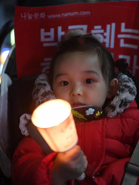 박근혜 대통령 퇴진을 요구하는 민중총궐기 대회가 열린 12일 서울 광화문광장 일대에서 한 어린이가 촛불을 들고 박근혜 대통령의 하야를 촉구하고 있다./권욱기자ukkwon@sedaily.com