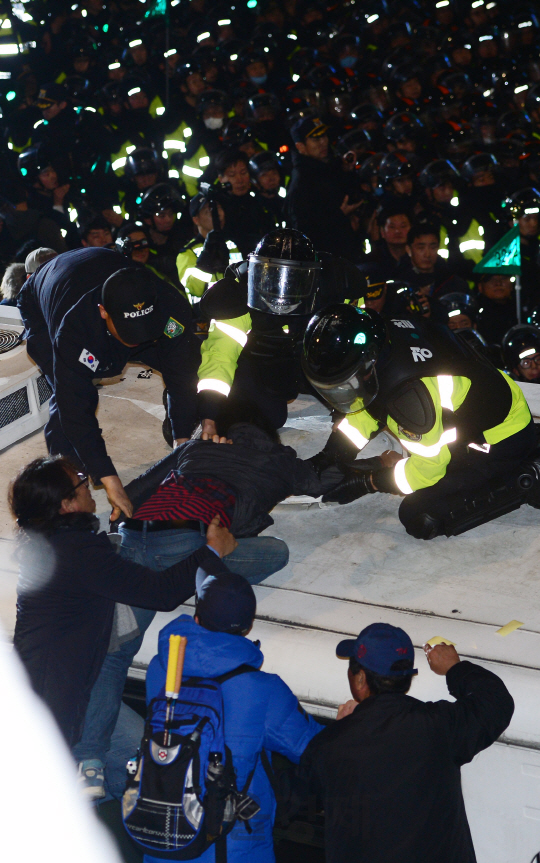 민중총궐기 대회를 마친 집회 참가자들이 12일 서울 경복궁역 사거리에서 청와대 방면으로 행진을 하다 경찰들과 대치하고 있다./사진공동취재단
