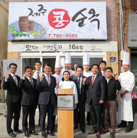 호텔신라의 대표적 사회공헌활동인 ‘맛있는 제주만들기’ 16호점 개점 기념식이 17일 서귀포시 대정읍 제주콩순옥 앞에서 열렸다. 오상순(앞줄 왼쪽 세번째부터) 제주신라호텔 총지배인, 차순옥 제주콩순옥 사장, 하주호 호텔신라 전무, 고낙천 제주신라면세점장 등 관계자들이 파이팅을 외치고 있다. 맛있는 제주만들기는 음식점을 운영하는 영세 자영업자를 선정해 호텔신라의 전문가들이 메뉴 조리법과 손님 응대 서비스 등을 전수하고 주방 설비와 인테리어도 지원하는 프로그램이다. /사진제공=호텔신라