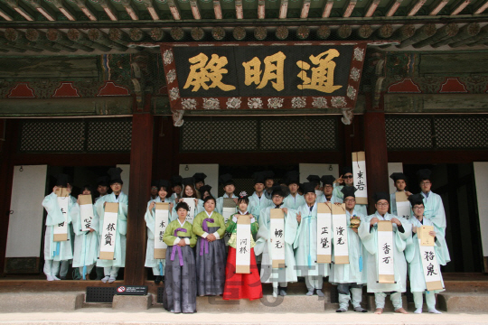 글로벌 게임사 라이엇 게임즈의 ‘문화유산 지킴이 참여 프로그램’에 참여한 게임 이용자들이 전통 복식과 관을 착용하고 기념촬영을 하고 있다./사진제공=라이엇게임즈