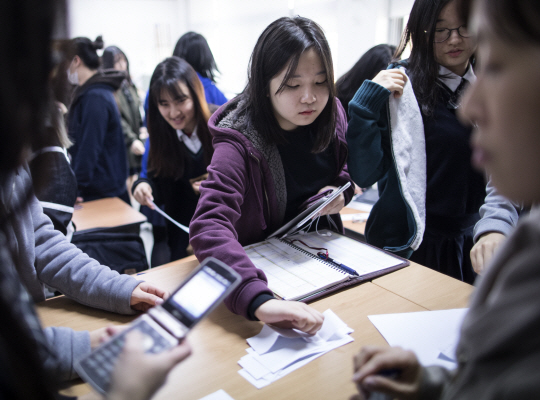 18일 서울 중구 이화여고에서 고3 학생들이 전날 치른 대학수학능력시험의 가채점 점수를 담임선생에게 내고 있다.  /연합뉴스