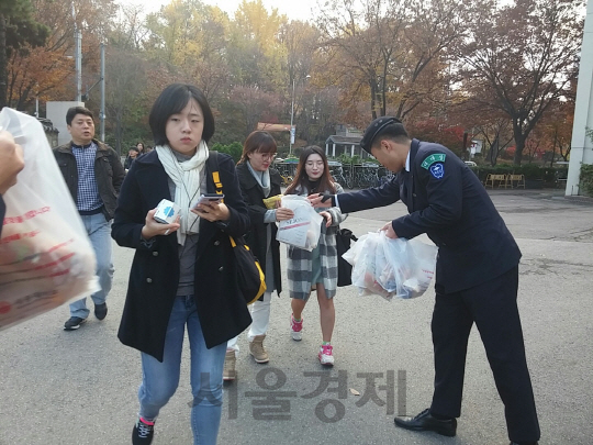 주요 대학들이 2017학년도 논술전형을 실시한 19일 오전 세종대학교 정문으로 들어오는 수험생들이 학교측이 시험 100점을 기원하며 마련한 음료수 1개와 빵 2개로 구성된 간식세트를 받아들고 시험장으로 들어가고 있다. /김민형기자