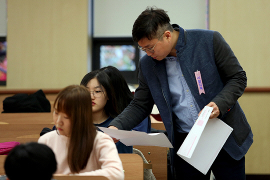 19일 오전 한양대 서울캠퍼스에서 한양대 시험감독관이 수시 논술고사에 응시한 수험생들에게 문제지를 나눠주고 있다. /연합뉴스